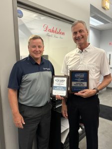 Photo of two Dahlsten employees holding a Platinum Motor Carrier Safety Award and Platinum Workplace Safety Award 